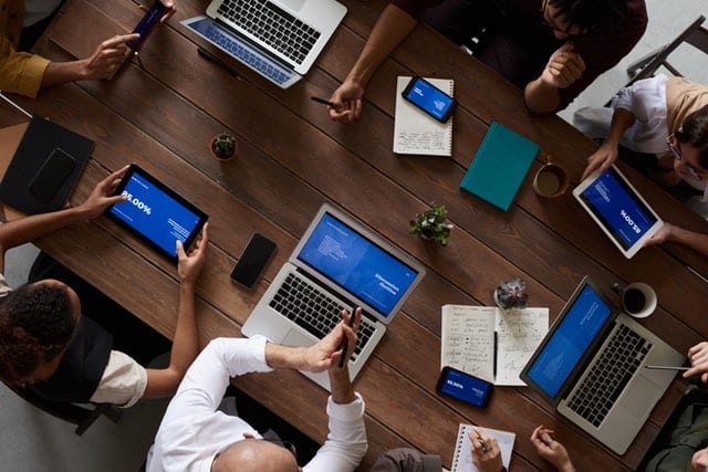 people at a table with their laptops