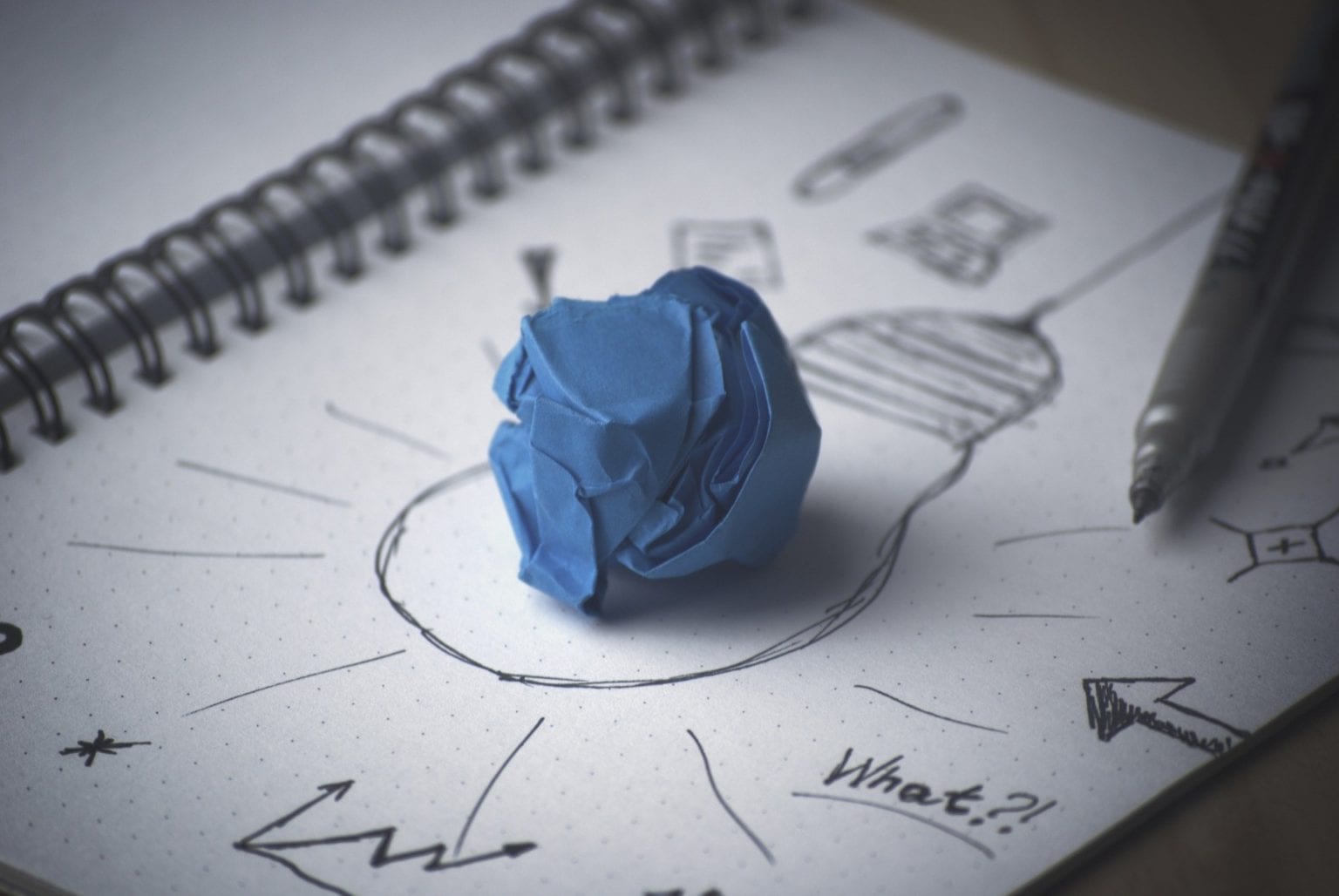 A sketch of a lightbulb with a wadded up blue paper in the middle